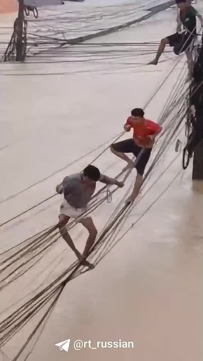 Тайцы вынуждены перемещаться по проводам как акробаты — в стране сильный потоп, местами уровень воды уже под 3 м