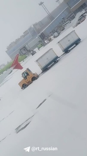 Буксир с багажом не может проехать по заснеженной территории аэропорта Домодедово