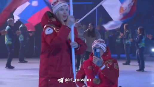 Горнолыжница Варвара Ворончихина и лыжник Иван Голубков с флагом России на церемонии закрытия Паралимпиады в Италии